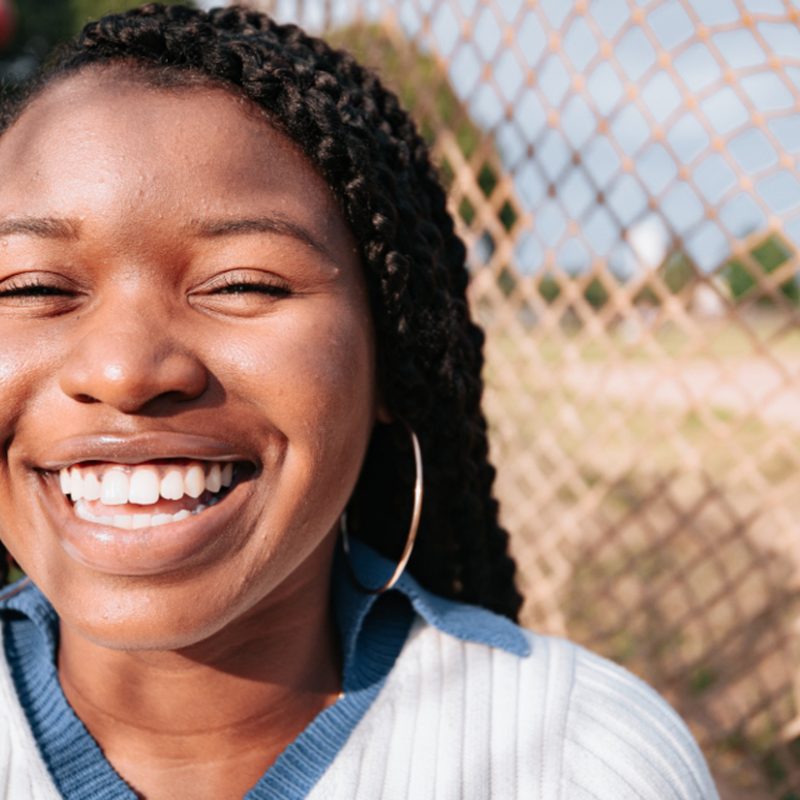 A woman smiling, photographed outdoors